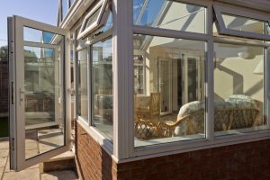 A conservatory with it's doors open and the sun shining on it