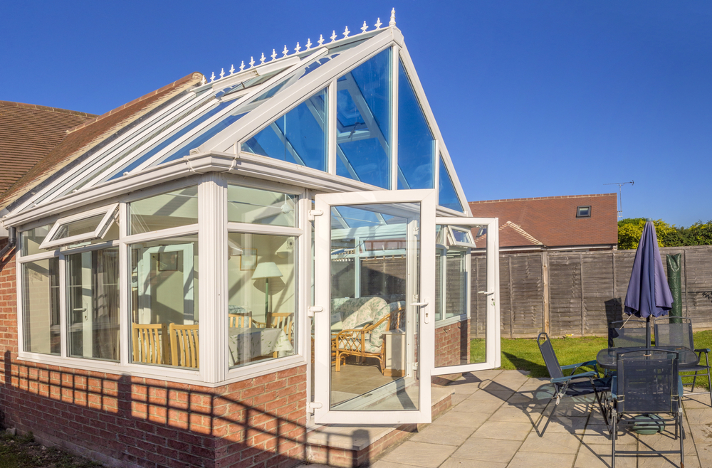 A conservatory with the the front doors open
